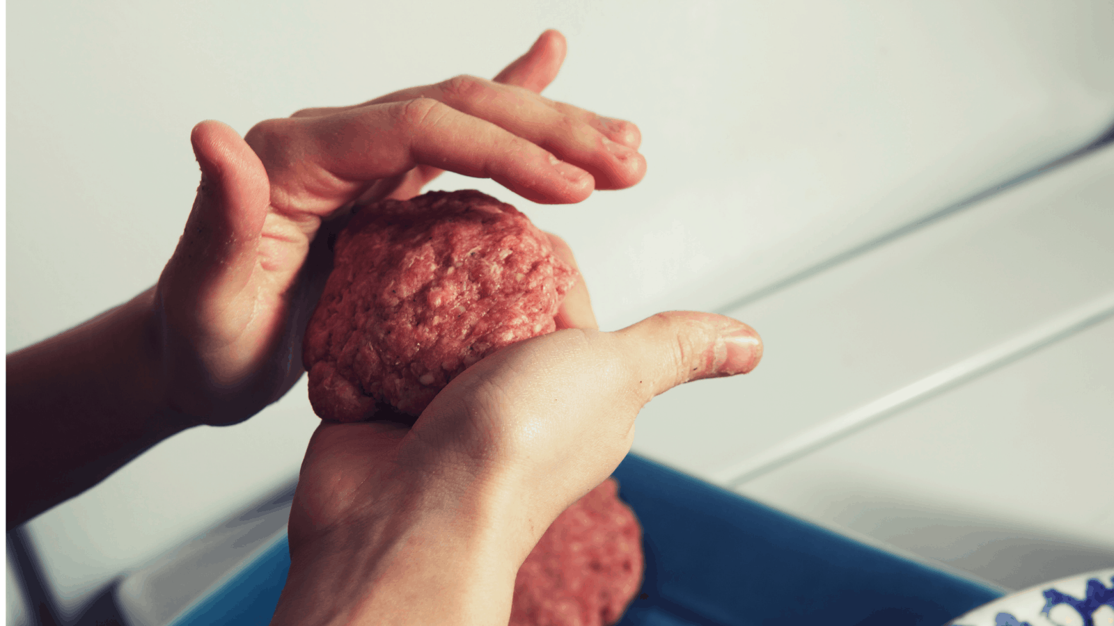 hands forming ground beef into burger